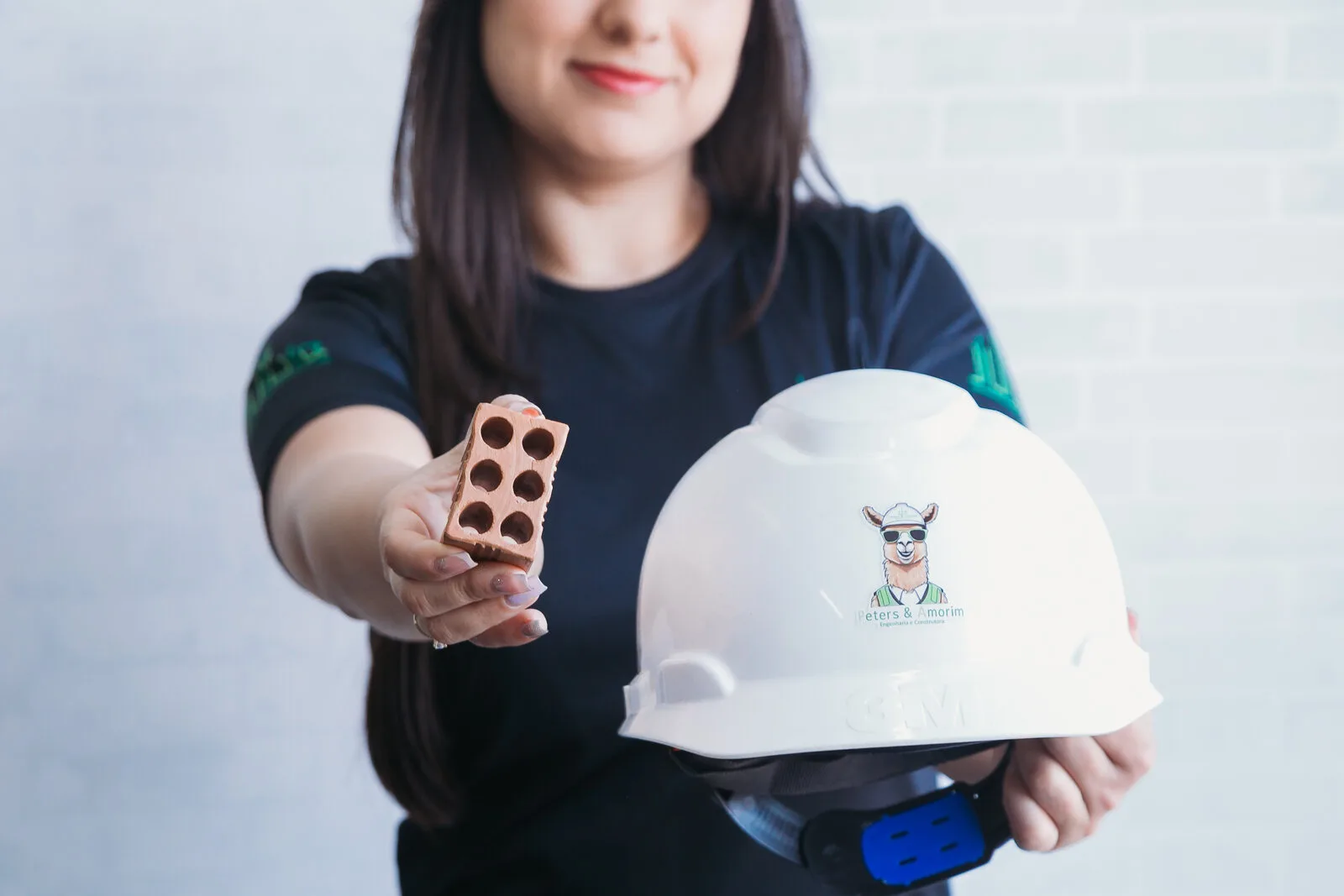 Profissional segurando tijolo e capacete de segurança